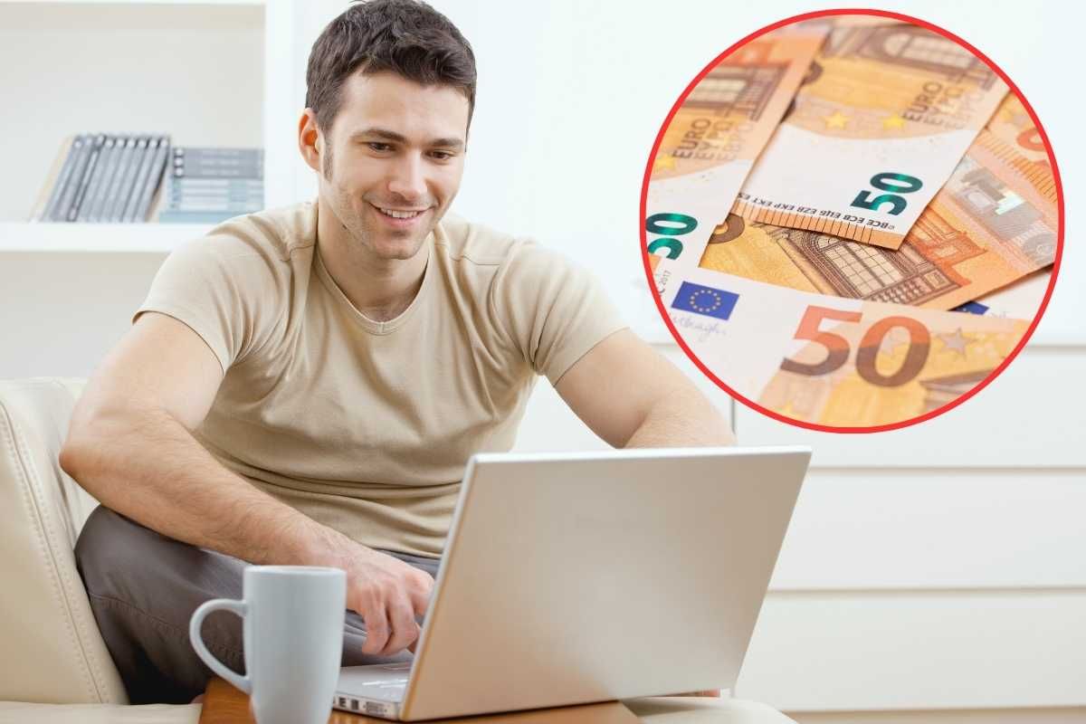 uomo al pc e soldi in secondo piano